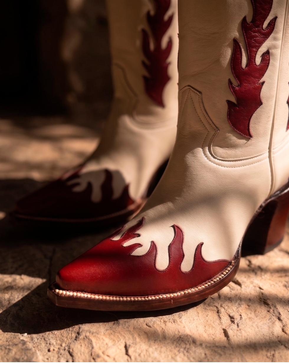 Boot toe close-up showing flame-cut red leather inlay against cream leather.