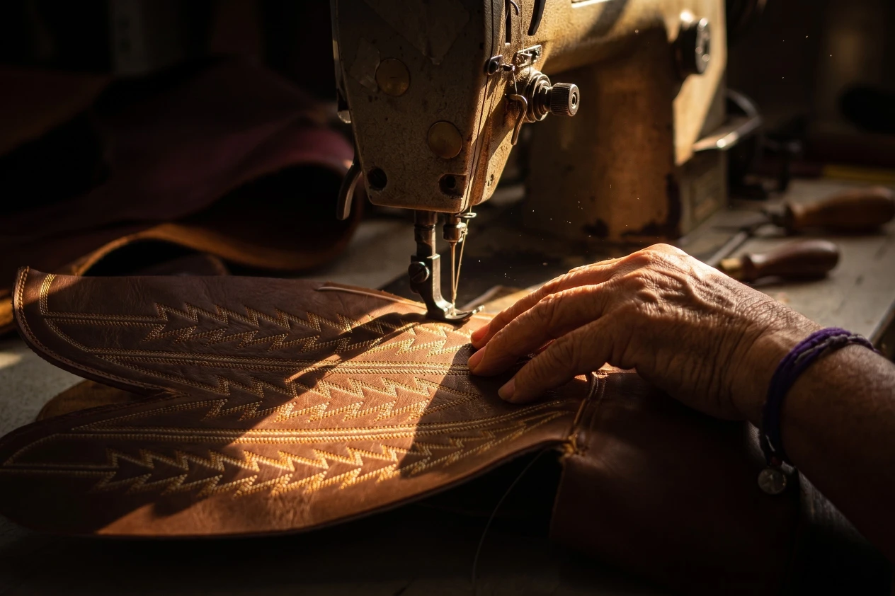 An artisan finishing a pair of Don Quijote Boots by hand in León, México.